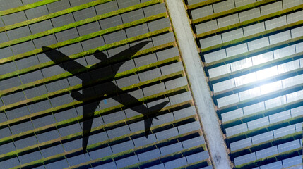 Wall Mural - Airplane shadow gliding over massive solar panel installation during sunny day. Sustainable aviation and renewable energy integration for eco friendly transportation future at commercial solar farm.