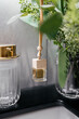 © Валерия Стоганенко - Home fragrance with wooden cover and houseplant. Perfume for car, Aroma diffuser air freshener. The concept of a pleasant aroma in the toilet, close-up. Modern minimalist bathroom