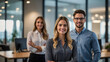 © Pablicus - Confident Business Team Smiling in Office Hallway with Professional Businesswoman and Businessman
