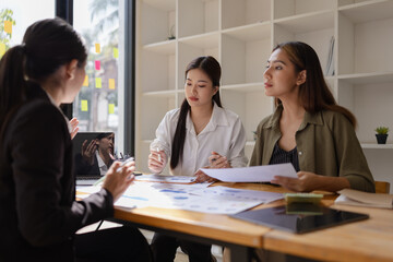 Wall Mural - Asian businesswoman teamwork working on laptop with finances analysis report at desk in office, business financing, accounting banking, Team of creative and business planning, 