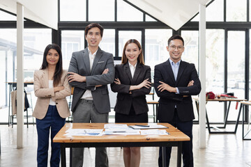 Wall Mural - Confident team of Asian business people stands at office. 