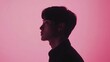 © Ayan - A young man in a dark shirt stands in profile against a vibrant pink background, gazing off to the side. The contrasting colors create a sense of mystery and intrigue.
