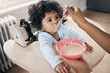 © peopleimages.com - Infant, parent hands and porridge in home, breakfast and nutrition for healthy growth. Kitchen, daughter and support in child development for wellness, organic formula and love for kid with fiber