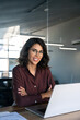 © Stock 4 You - Vertical portrait of professional it specialist latin hispanic business lady working on laptop pc sitting at desk in modern office. Young middle eastern indian woman using computer technology for work
