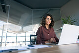 Young businesswoman professional employee using pc doing online banking analysing at workplace. Latin hispanic middle age business woman working on laptop computer in modern office. Banner, copy space