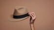 © Dueo - Hand displaying a stylish hat, fingers gently holding the brim, perfect for fashion accessory mockups.