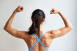 © 9nong - Rear view of strong fit healthy Asian woman with strong muscle and lean body, flexing her back shoulder muscle, concept for fitness gym, sport woman, muscle building, body building, strong and healthy