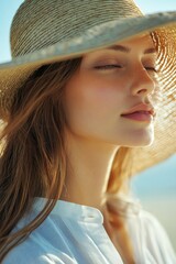 Wall Mural - A woman relaxes on a sunny beach while wearing a straw hat, enjoying her vacation