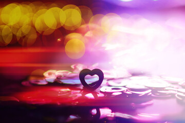 Wall Mural - Abstract colored background. Red toy in the shape of a heart on a glitter and bokeh background.