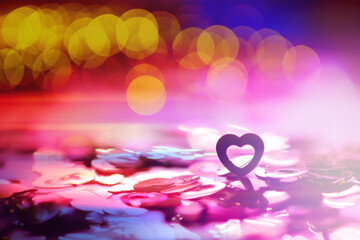 Wall Mural - Abstract colored background. Red toy in the shape of a heart on a glitter and bokeh background.