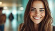© JoxyAimages - A cheerful woman with long brown hair and freckles smiles brightly in a corridor setting, creating a sense of warmth and positivity in a casual environment.