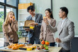 © NINENII - Asian business team are excited business success with inspiration from their excellent financial results, celebration successful deal with champagne and pizza in the workplace.