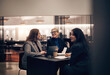 © Flamingo Images - Businesswomen laughing during a meeting together in a hotel lobby