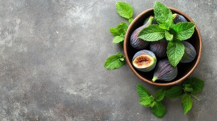 Wall Mural - Bowl of fresh figs with mint leaves on a rustic background