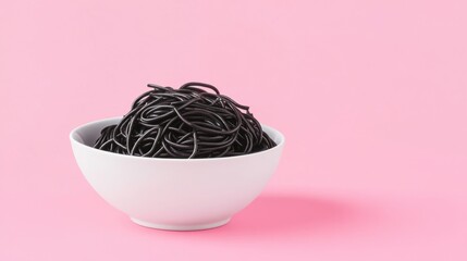 Poster - Black squid ink spaghetti in bowl on pink background