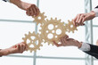 © Katsiaryna - Hands of people office workers business partners making common picture of wooden gears on table, selective focus