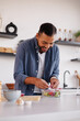 © Dmytro Hai - Cheerful african american man adding onion in salad in modern kitchen