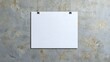 © saichon - A blank white sheet pinned to a textured gray wall, offering a minimalist and versatile background for various applications.