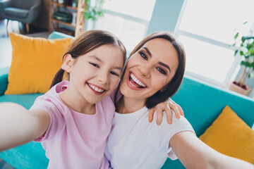 Wall Mural - Photo of cheerful family lovely mommy and daughter recording video weekend indoors living room