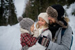 © Halfpoint - Young family is enjoying winter holiday in the mountains, standing in the middle of snowy forest.
