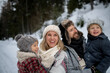 © Halfpoint - Young family is enjoying winter holiday in the mountains, standing in the middle of snowy forest.