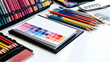 © sonswirl - A flat lay of colorful pencils and a notebook with a color chart on a white surface.