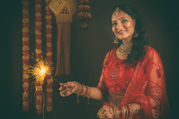 Young Indian female in Red Ethnic costume for celebration of Indian Hindu Festival. Celebration of Diwali.