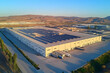 © Emons - Renewable Energy - Aerial view of a large industrial warehouse with solar panels and trucks in the foreground.