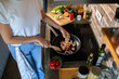 © Geber86 - Young woman cooking healthy vegetables in modern kitchen