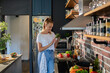 © Geber86 - Young woman filming cooking tutorial in kitchen with fresh vegetables and eggs