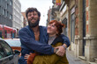 © Connect Images - Smiling bearded man giving piggyback ride to a cheerful redhead woman on a city street, Brussels, Belgium