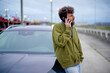 © Connect Images - Man talking on a mobile phone while leaning on his car by the roadside, Belgium