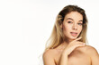 © LIGHTFIELD STUDIOS - A young woman smiles thoughtfully, exuding confidence and beauty in a serene setting.