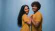 © Yuliia - Blue studio background happy multiracial couple showing heart shape St Valentines Day romantic relationships love married man and woman sincere feelings followers kindness volunteering Ukraine support