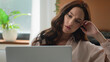© Yuliia - Pensive thinking Caucasian young girl thoughtful adult woman think business idea solution professional businesswoman female user at home office using laptop typing computer message internet working