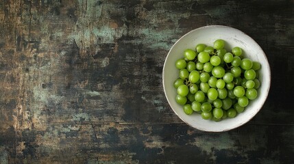 Wall Mural - Green grapes in a white bowl on a rustic wooden background top view