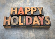 © Pixelcraze - Happy holidays in wood type. Happy holidays, text in letterpress wood type against grunge metal background