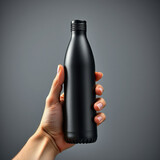 Close-up of male hand holding black reusable steel stainless thermo water bottle isolated on background