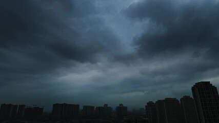 Wall Mural - time lapse of dark clouds over a city