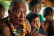 © Infinity Lens - a Hawaiian elder storytelling with children gathered around, learning about their culture.