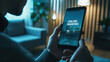© Fleuronica - A user engages with an online banking app on their smartphone while relaxed in a softly lit living room at night
