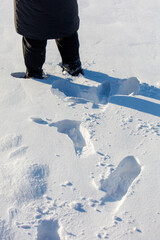 Wall Mural - A person is standing in the snow with their feet in the snow