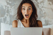 © Di Studio - surprised brunette woman looking at laptop