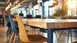 © Justlight - A large wooden communal table with mismatched chairs serves as a central gathering spot for networking and collaboration.