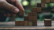 © George Louris  🜲 - A hand adjusting wooden blocks in an increasing height sequence, symbolizing growth and progress in business or learning.
