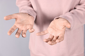 Wall Mural - Man holding something on grey background, closeup