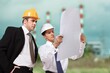 © BillionPhotos.com - Engineers examining survey standing industrial facility