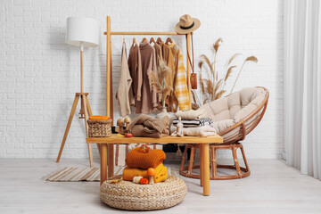 Wall Mural - Rack with stylish clothes and autumn decorations on table in dressing room