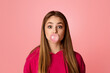 © Prostock-studio - Teenage girl with wide open eyes. Blowing bubble of chewing gum, on pink background, studio shot, free space © Prostock-studio - Teenage girl with wide open eyes. Blowing bubble of chewing gum, on pink background, studio shot, free space