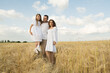 © sharshonm - farmer carries little daughter in his arms through a field of wheat. happy child and father are playing in field of ripening wheat.Beautiful family in the park.